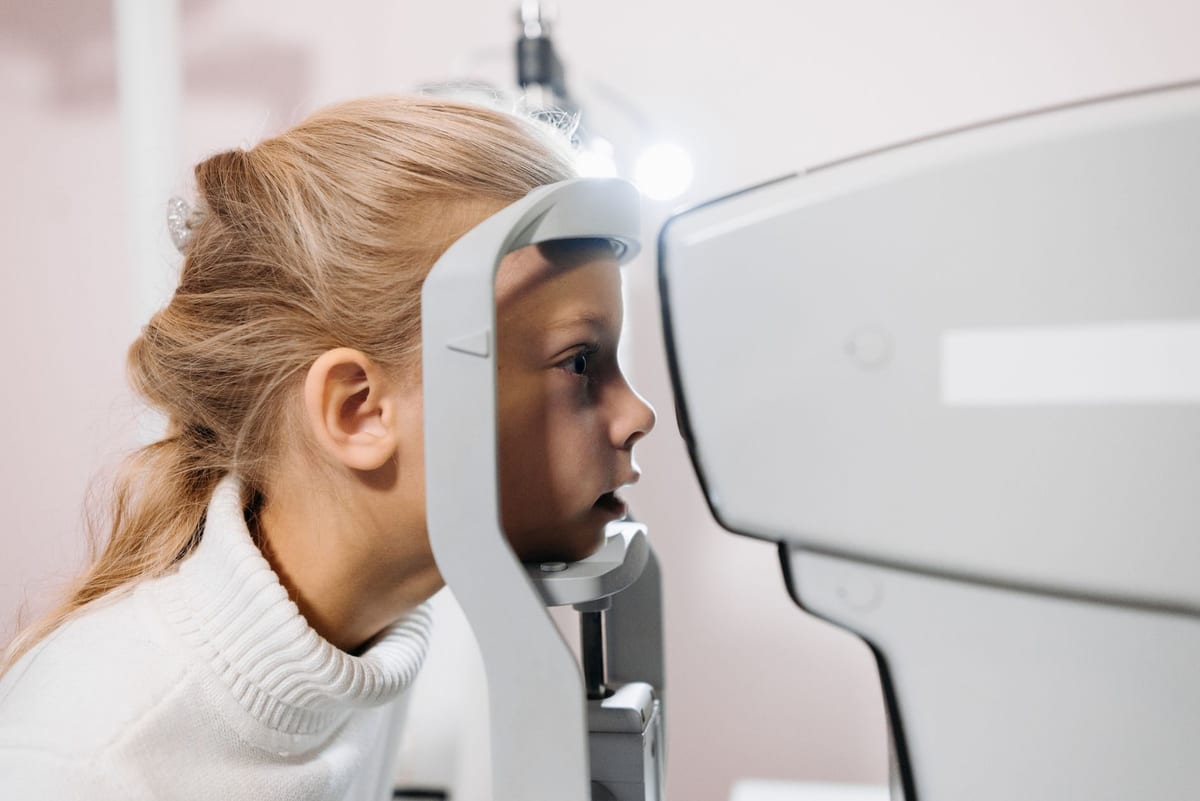 A child having her eyes measured at an auto-refractor